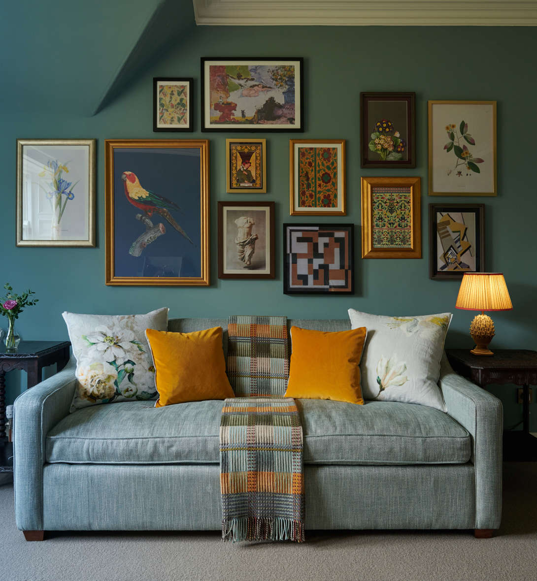 Stylish seating area in the Cromlix Hotel, Dunblane, featuring a blue sofa with colorful accents and a gallery wall of framed pictures.
